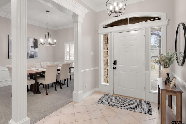 foyer entrance with light carpet, decorative columns, a wealth of natural light, and ornamental molding