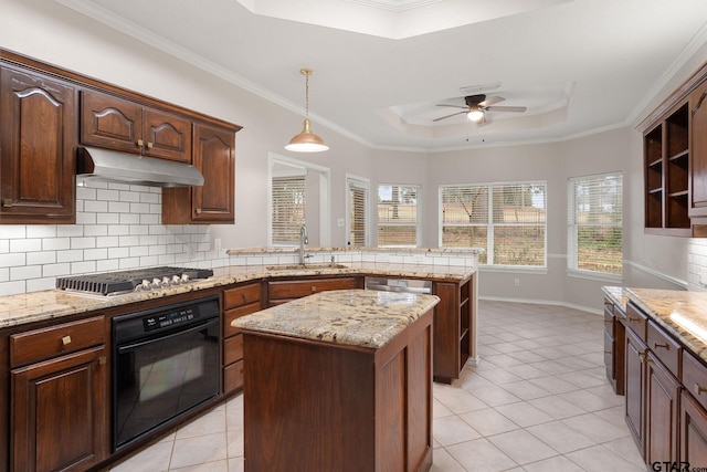 kitchen featuring a center island, a raised ceiling, sink, black oven, and stainless steel gas cooktop