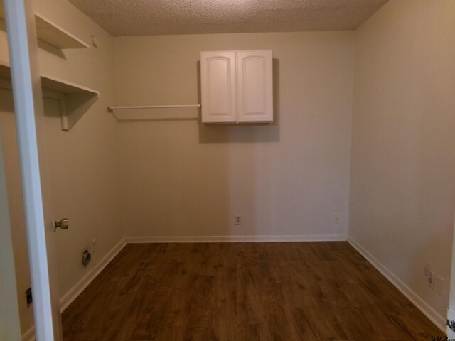 803 Corey, Whitehouse, TX 75791 - washroom with cabinet space, dark wood-style floors, a textured ceiling, and baseboards
