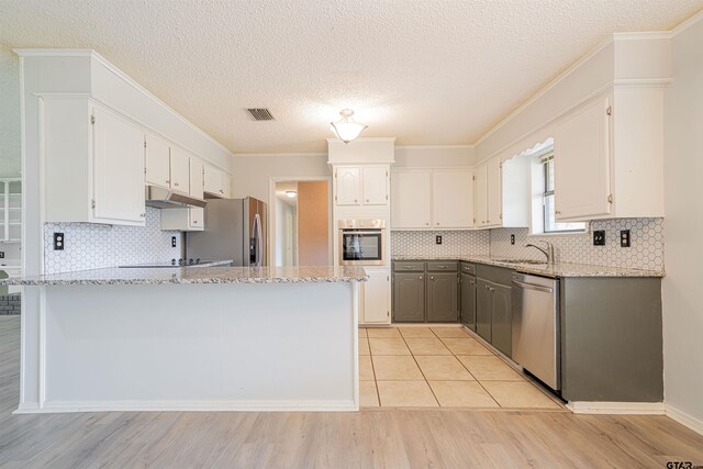 kitchen featuring white cabinets, stainless steel appliances, and light hardwood / wood-style flooring