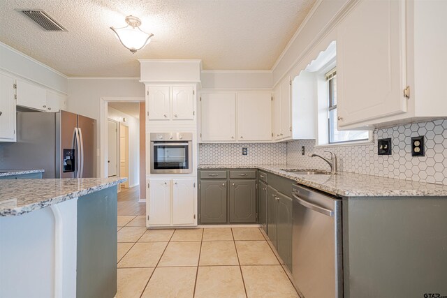 kitchen featuring gray cabinets, appliances with stainless steel finishes, and white cabinets