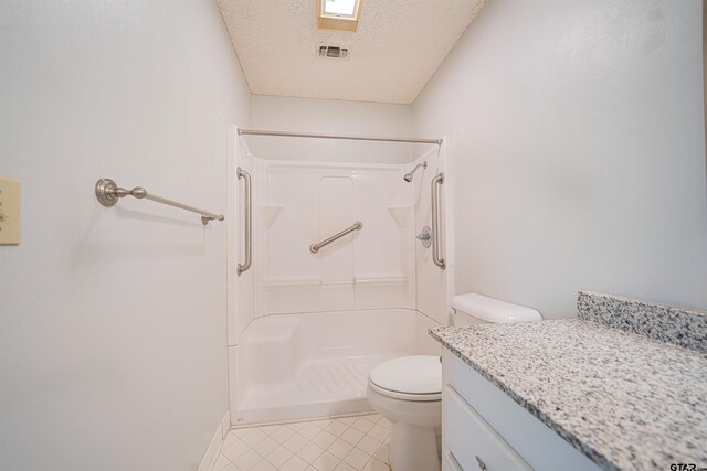 bathroom featuring a shower, a textured ceiling, toilet, and vanity