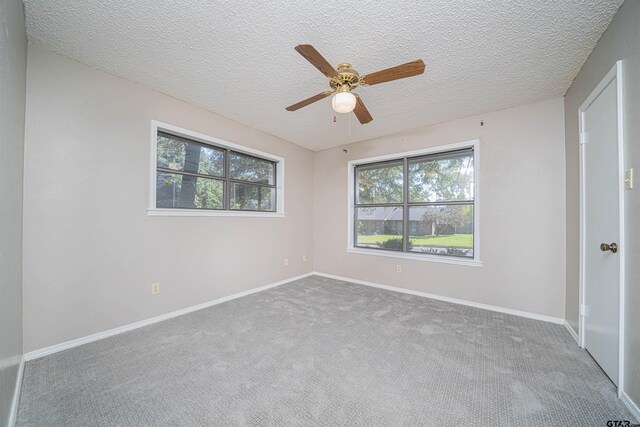 carpeted empty room featuring a textured ceiling and ceiling fan