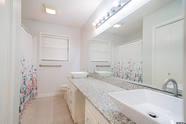 bathroom with vanity, tile patterned floors, a textured ceiling, and toilet