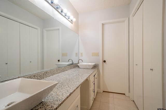 bathroom featuring vanity, tile patterned flooring, and a textured ceiling