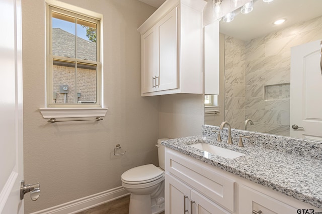 bathroom with toilet, vanity, and wood-type flooring