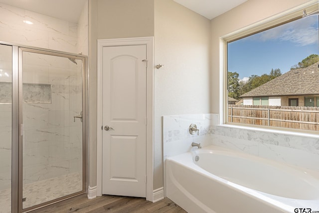 bathroom with independent shower and bath and wood-type flooring