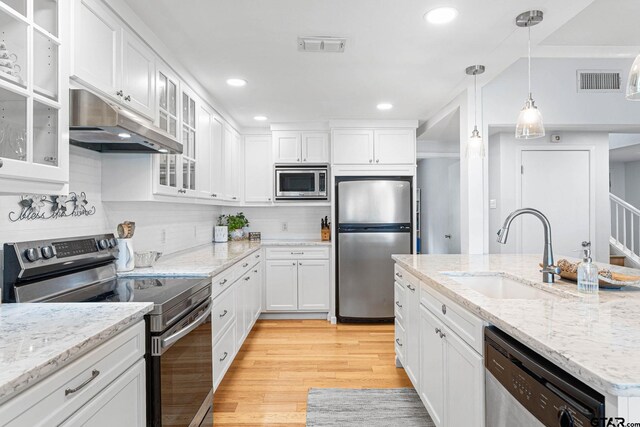 21028 Bay Shore Dr, Flint, TX 75762 - kitchen with stainless steel appliances, under cabinet range hood, white cabinetry, light wood-style floors, and recessed lighting
