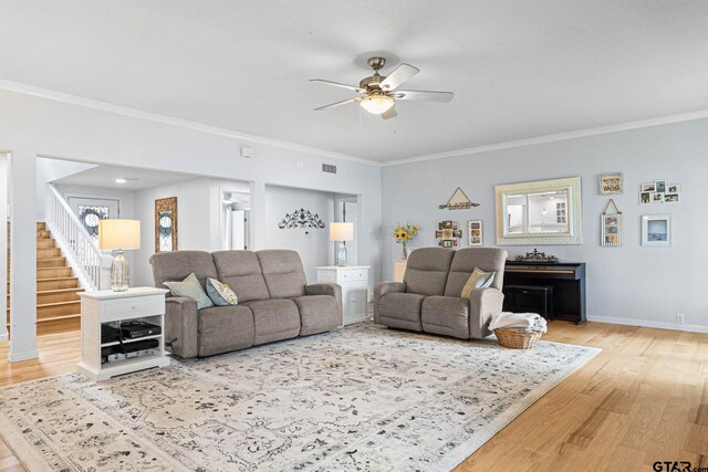 21028 Bay Shore Dr, Flint, TX 75762 - living area featuring ceiling fan, wood finished floors, crown molding, and stairway