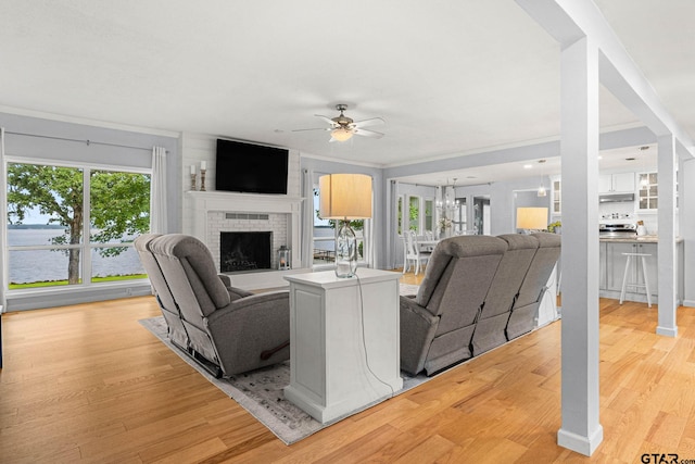 21028 Bay Shore Dr, Flint, TX 75762 - living area with ceiling fan, light wood finished floors, a fireplace, and a water view