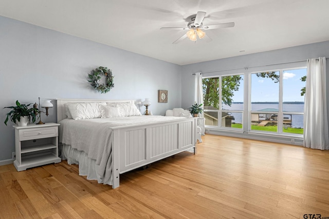 21028 Bay Shore Dr, Flint, TX 75762 - bedroom featuring light wood-style flooring, ceiling fan, and a water view