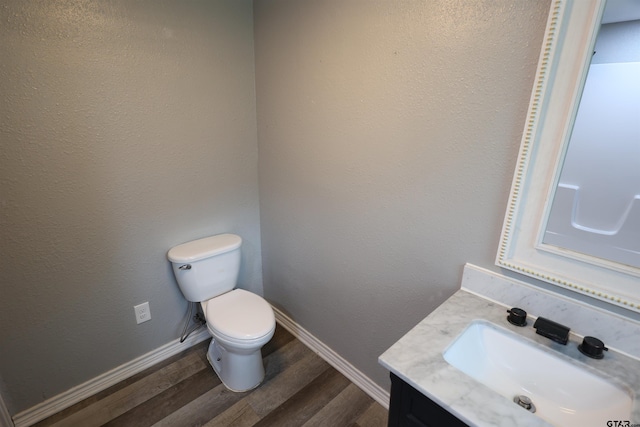 199 Linda Dr, Jefferson, TX 75657 - half bath featuring toilet, vanity, wood finished floors, and baseboards