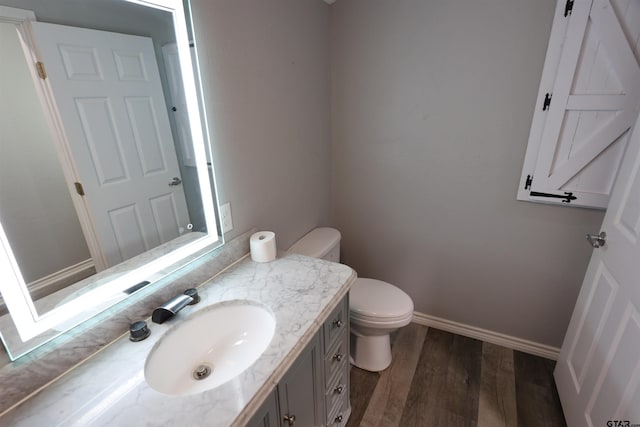 199 Linda Dr, Jefferson, TX 75657 - bathroom with vanity, wood finished floors, toilet, and baseboards