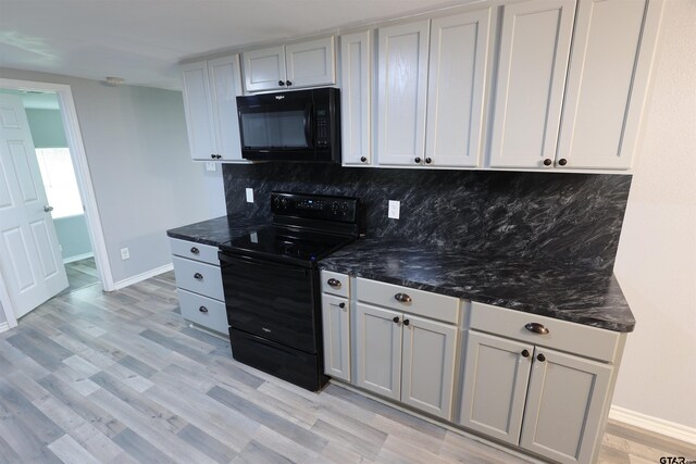 199 Linda Dr, Jefferson, TX 75657 - kitchen with black appliances, baseboards, decorative backsplash, light wood-style flooring, and dark stone countertops