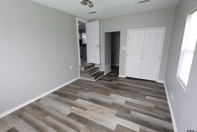 199 Linda Dr, Jefferson, TX 75657 - unfurnished bedroom featuring wood finished floors, multiple windows, and baseboards