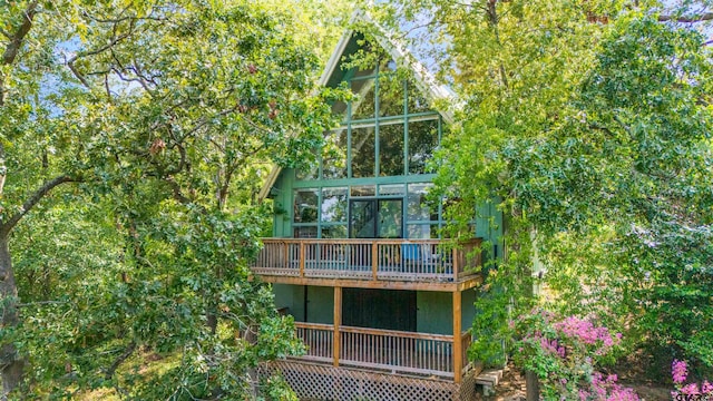 back of property featuring a sunroom and a wooden deck