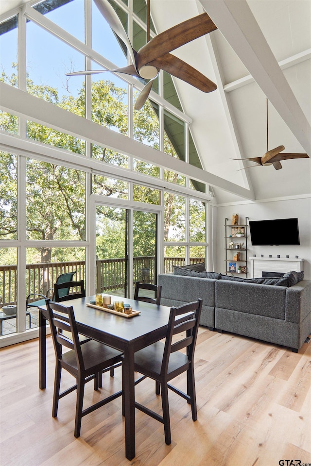 sunroom / solarium featuring a wealth of natural light, ceiling fan, and lofted ceiling with beams