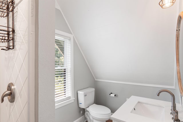 bathroom with vanity, toilet, and vaulted ceiling