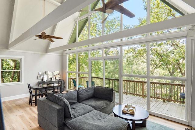 sunroom featuring vaulted ceiling with beams and ceiling fan