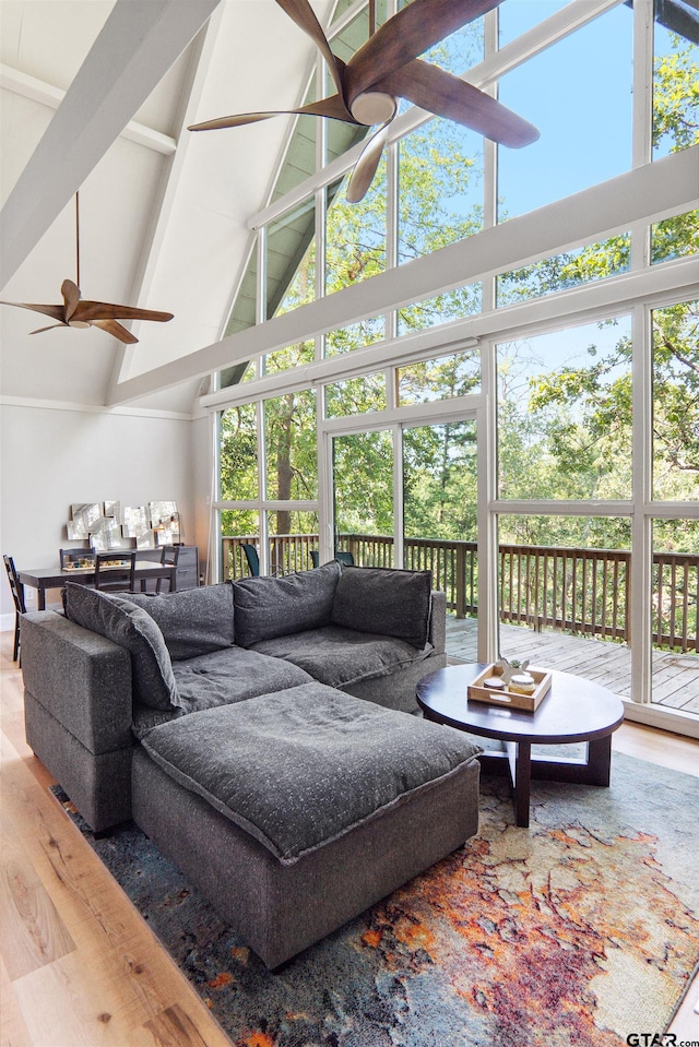 sunroom with vaulted ceiling with beams, a healthy amount of sunlight, and ceiling fan