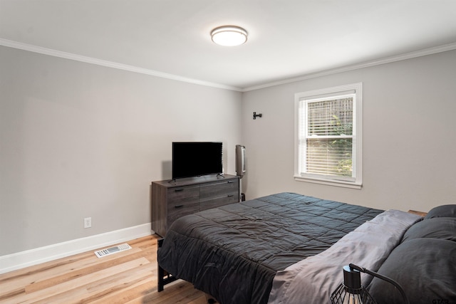 bedroom featuring wood-type flooring and crown molding