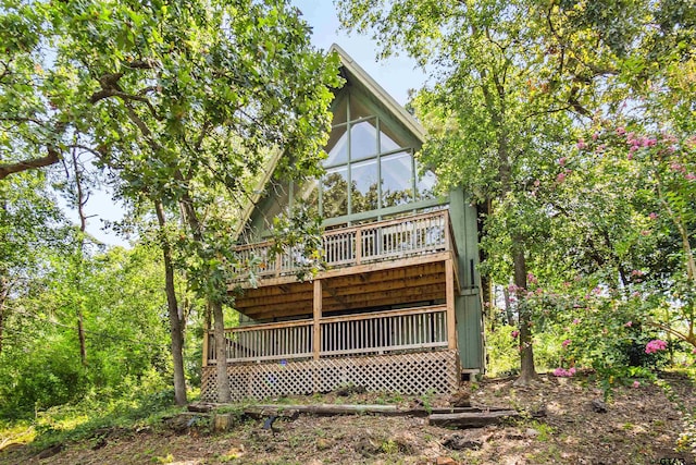 rear view of house featuring a wooden deck