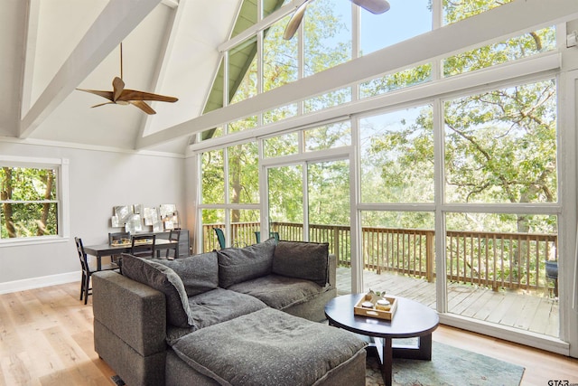 sunroom featuring vaulted ceiling with beams and ceiling fan