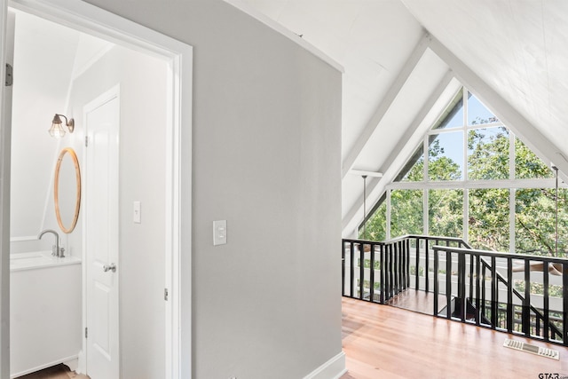 additional living space with wood-type flooring and vaulted ceiling