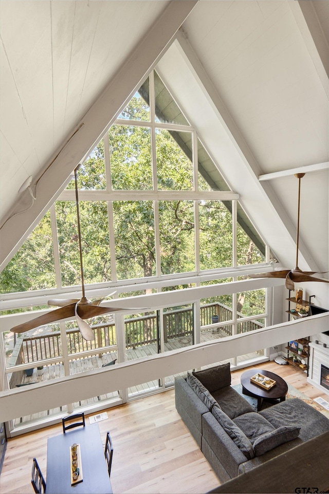 living room with wood-type flooring, a healthy amount of sunlight, and beam ceiling