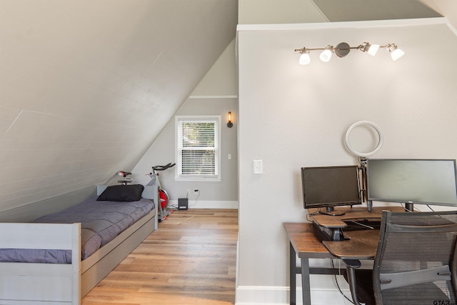 bedroom with lofted ceiling and light hardwood / wood-style flooring