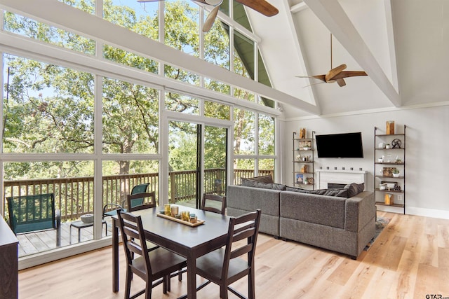 sunroom / solarium with ceiling fan, plenty of natural light, and vaulted ceiling with beams