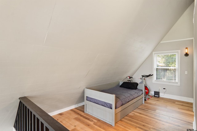 bedroom featuring hardwood / wood-style flooring and lofted ceiling