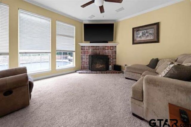 living room with a brick fireplace, ornamental molding, ceiling fan, and carpet