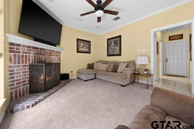 living room with crown molding, a brick fireplace, light carpet, and ceiling fan