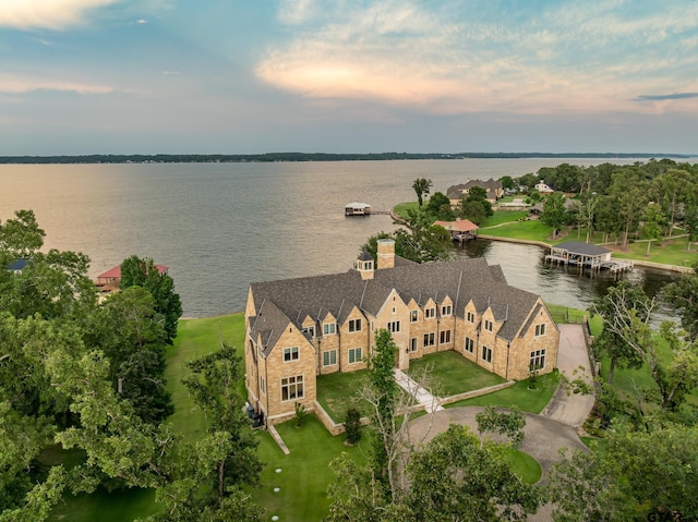 aerial view at dusk featuring a water view