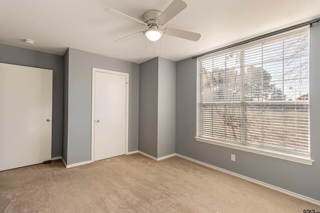 unfurnished bedroom featuring a closet, ceiling fan, and light carpet