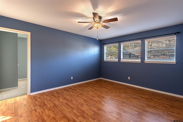 spare room with ceiling fan and wood-type flooring