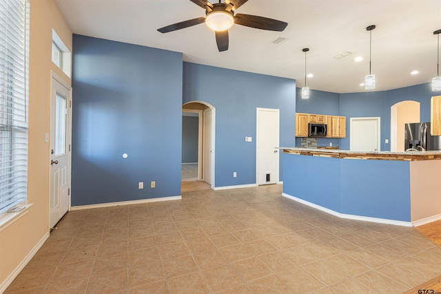 kitchen featuring decorative light fixtures, light brown cabinets, appliances with stainless steel finishes, and light tile patterned flooring