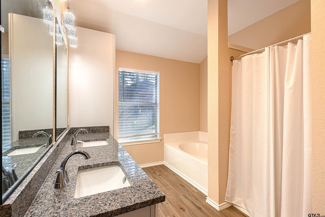 bathroom with wood-type flooring, a tub to relax in, vanity, and lofted ceiling