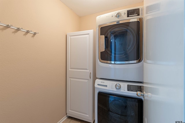 washroom with cabinets and stacked washer and dryer