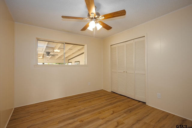 unfurnished bedroom featuring wood-type flooring, a closet, and ceiling fan