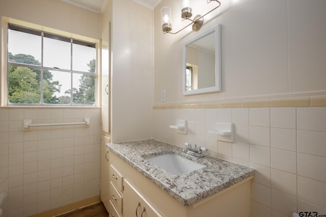 bathroom featuring crown molding, vanity, and tile walls