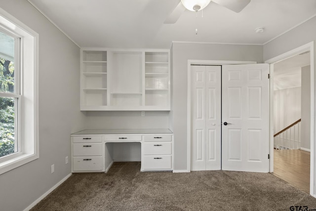 unfurnished office featuring ceiling fan, crown molding, and carpet