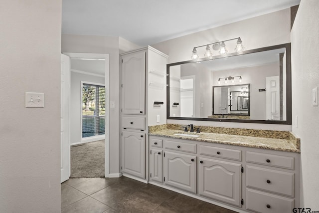 bathroom featuring tile patterned flooring, vanity, and crown molding