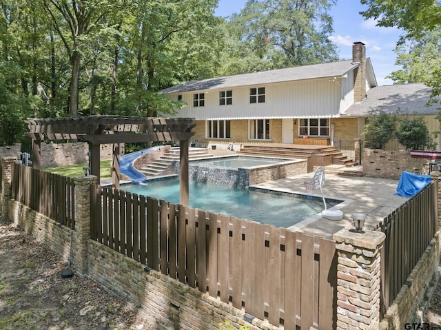 view of swimming pool featuring pool water feature, a patio area, a water slide, and an outdoor hot tub