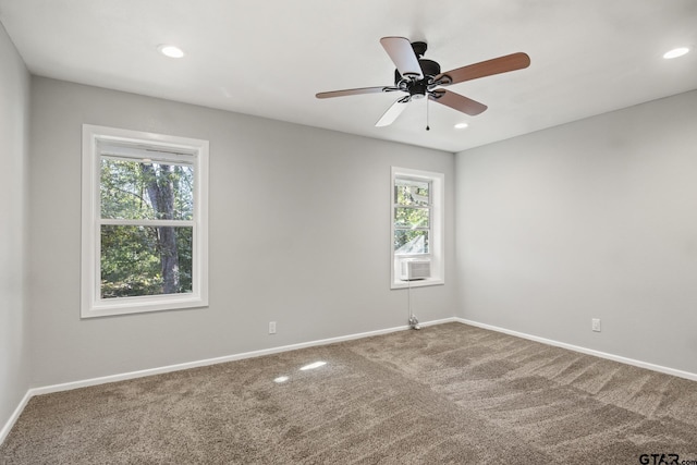 carpeted empty room with ceiling fan, plenty of natural light, and cooling unit