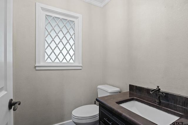 bathroom with vanity, toilet, and ornamental molding