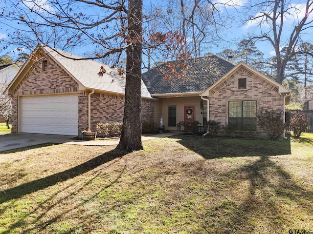 view of front of property with brick siding, driveway, a front yard, and an attached garage