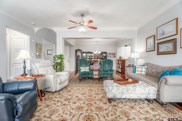 living room featuring ceiling fan with notable chandelier and ornamental molding