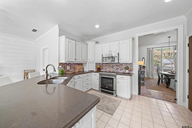 11213 Chasewood Dr, Tyler, TX 75703 - kitchen featuring stainless steel appliances, a sink, dark countertops, light tile patterned flooring, and white cabinetry
